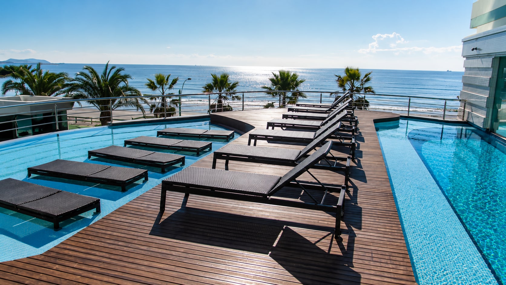 Deck de piscinas do Atlantic Paradise com espreguiçadeiras em fileira e vista panorâmica para o oceano
